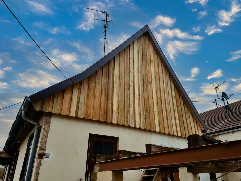 Maison à toit pointu avec bardage en bois sur l'une des faces