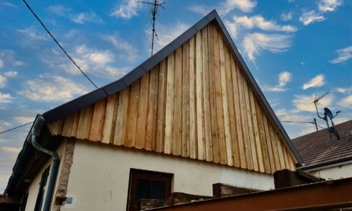 Maison à toit pointu avec bardage en bois sur l'une des faces